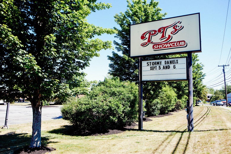 A cheap-looking sign next to a parking lot advertises Stormy Daniels' upcoming appearance.